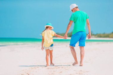 Küçük kız ve mutlu baba kumsal tatili boyunca eğleniyorlar.