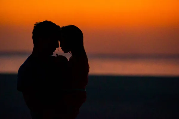 Kleine Mädchen und Papa Silhouette im Sonnenuntergang am Strand — Stockfoto