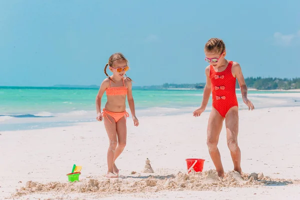 Imádnivaló kislány játszik strand játékok fehér trópusi strand — Stock Fotó