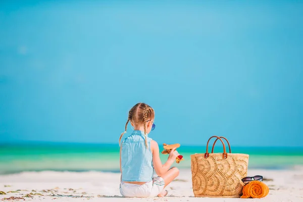 Niña feliz con avión de juguete en las manos en la playa de arena blanca. —  Fotos de Stock