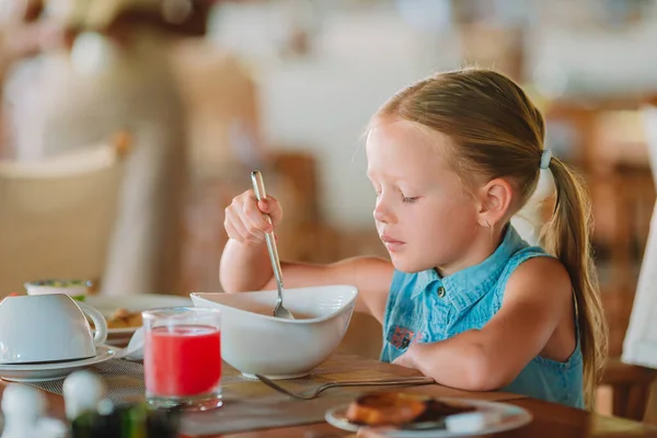 Adorable niña tomando el desayuno en la cafetería al aire libre — Foto de Stock