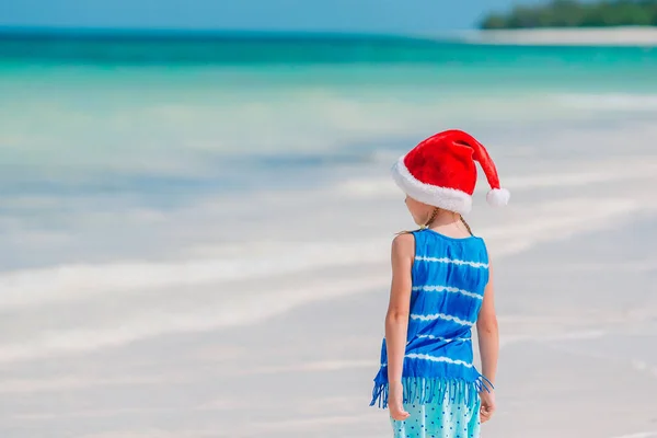 热带海滩上圣诞老人帽的可爱小女孩 — 图库照片