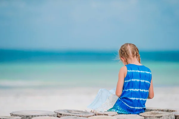 Niña escuchando música en auriculares en la playa caribeña — Foto de Stock