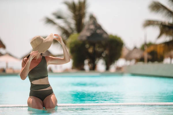 Mulher relaxante na piscina em um resort de hotel de luxo desfrutando de férias perfeitas na praia — Fotografia de Stock
