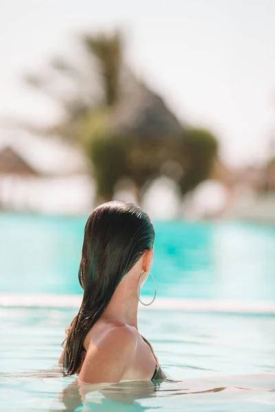 Mulher relaxante na piscina em um resort de hotel de luxo desfrutando de férias perfeitas na praia — Fotografia de Stock