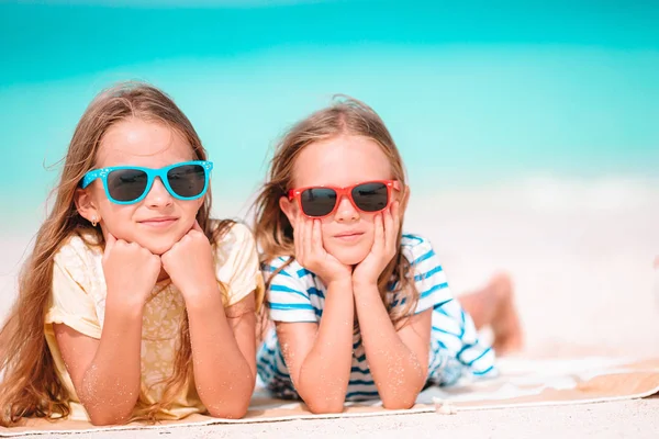 Kleine fröhliche lustige Mädchen haben viel Spaß am tropischen Strand, wo sie zusammen spielen. Sonniger Tag mit Regen im Meer — Stockfoto