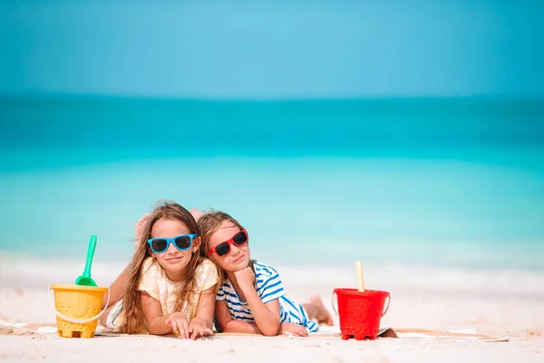 Twee kinderen die zandkasteel maken en zich vermaken op het tropische strand — Stockfoto