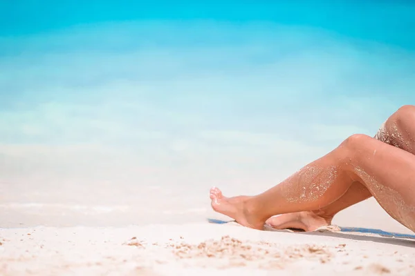 Womans feet on the white sand beach in shallow water — Stock Photo, Image
