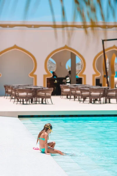 Adorable little girls playing in outdoor swimming pool on vacation — Stock Photo, Image