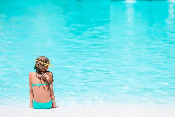 Adorable little girl swimming at outdoor swimming pool — Stock Photo, Image