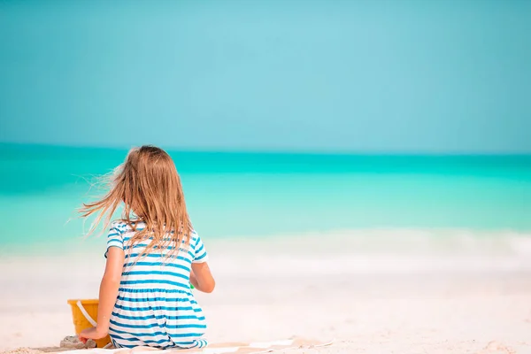 Klein meisje op tropisch wit strand maken zand kasteel — Stockfoto