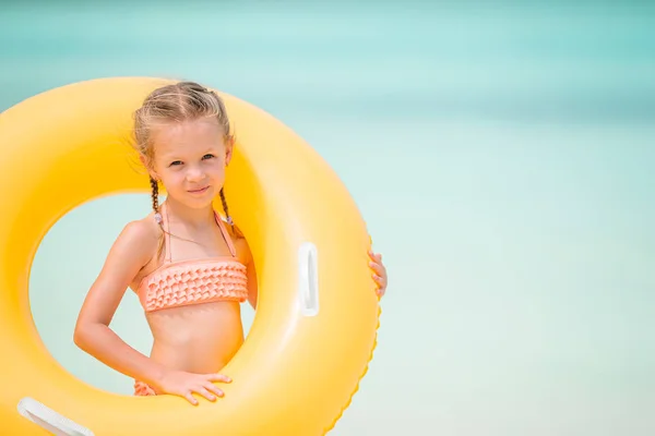 Szczęśliwy dzieciak z nadmuchiwanym gumowym kółkiem bawiący się na plaży — Zdjęcie stockowe