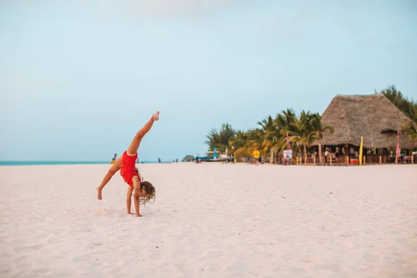 Schattig actief klein meisje aan het strand tijdens de zomervakantie — Stockfoto