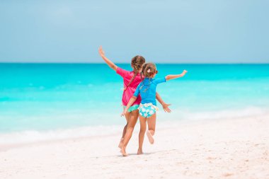 Küçük kızlar tropikal plaj birlikte sığ su oynarken eğleniyor