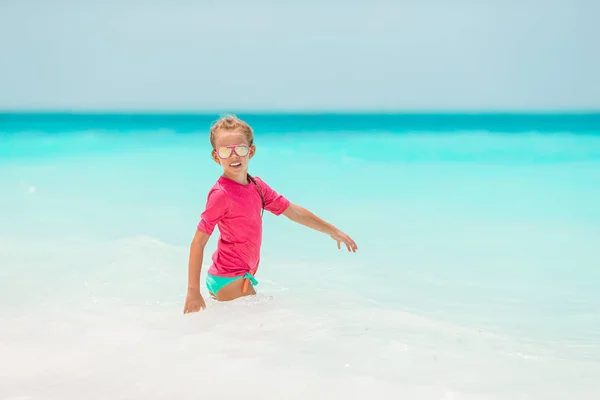 Entzückendes kleines Mädchen am Strand, das viel Spaß im Wasser hat — Stockfoto