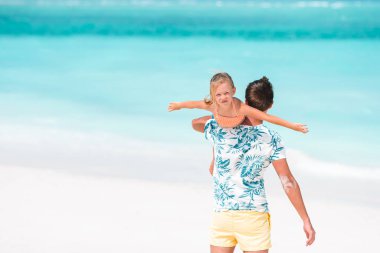 Küçük kız ve mutlu baba kumsal tatili boyunca eğleniyorlar.