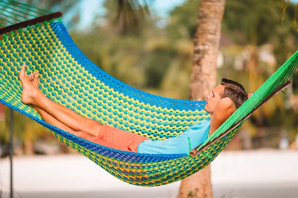 Young man with laptop at hammock on tropical vacation — Stock Photo, Image