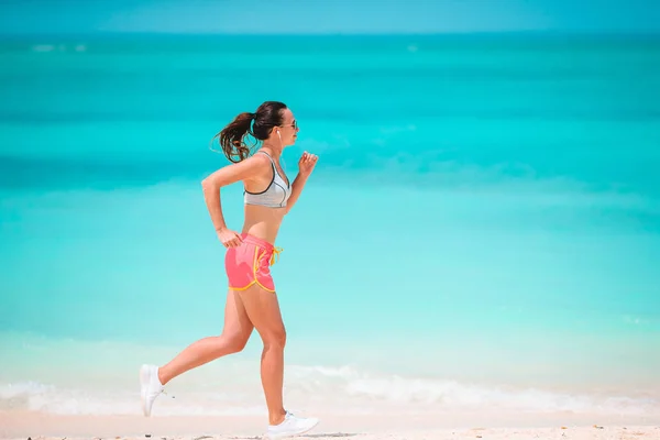 Ajuste mujer joven en la playa tropical en ropa deportiva —  Fotos de Stock