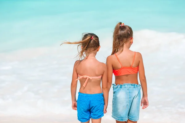 Little happy funny girls have a lot of fun at tropical beach playing together. — Stock Photo, Image