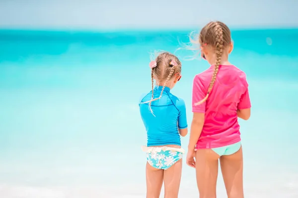 Pequeñas chicas divertidas felices tienen un montón de diversión en la playa tropical jugando juntos. —  Fotos de Stock