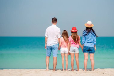 Yaz tatili boyunca sahilde mutlu bir aile.