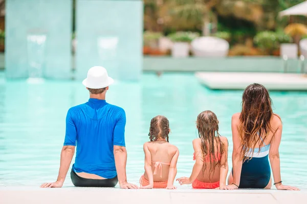 Счастливая семья из четырех человек в открытом бассейне — стоковое фото