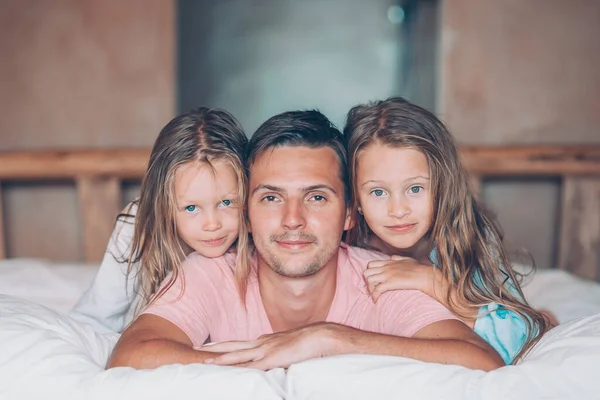 Vader met twee schattige kleine meisjes hebben plezier in bed glimlachen — Stockfoto