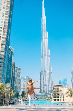 Arka planda Burj Halife gökdeleniyle Dubai 'de yürüyen mutlu bir aile..