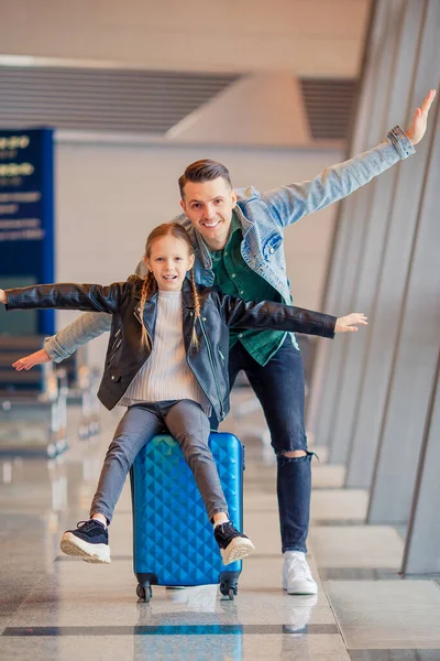 Familia feliz con equipaje y tarjeta de embarque en el aeropuerto esperando el embarque —  Fotos de Stock