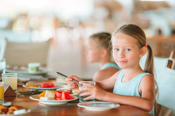 Adorable niña tomando el desayuno en la cafetería al aire libre —  Fotos de Stock