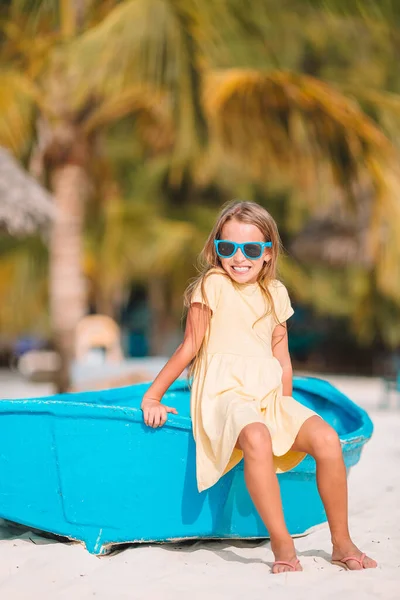Adorable little girl on boat on white beach — Stock Photo, Image