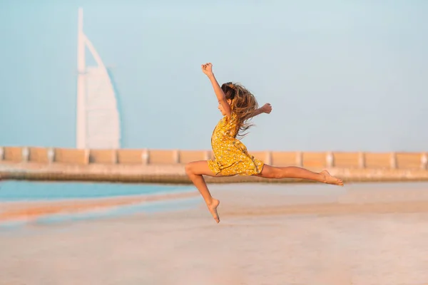 Adorable happy little girl on white beach at sunset. — Stock Photo, Image