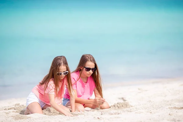 Duas meninas felizes se divertem muito na praia tropical jogando juntas — Fotografia de Stock