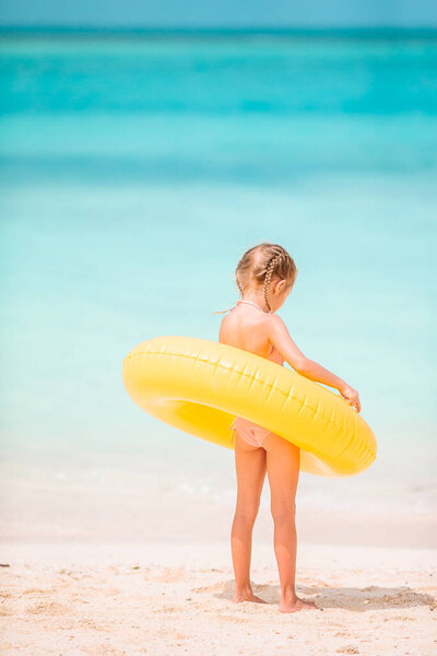 Happy kid with inflatable rubber circle having fun on the beach