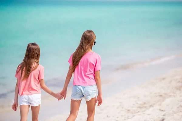 Pequenas meninas engraçadas felizes se divertir muito na praia tropical jogando juntos. — Fotografia de Stock