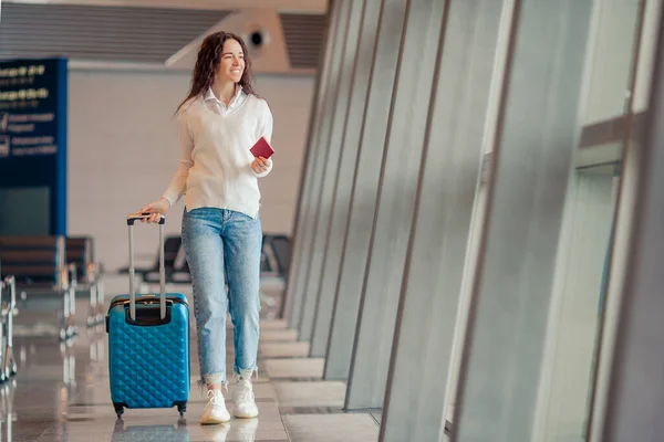 Giovane donna con bagagli in aeroporto internazionale. Passeggero di una compagnia aerea in una lounge dell'aeroporto in attesa di un aereo di volo — Foto Stock