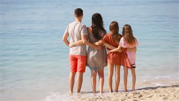 Молодая семья из четырех человек на пляжном отдыхе — стоковое видео