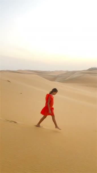 Κορίτσι ανάμεσα σε αμμόλοφους στην έρημο Rub al-Khali στα Ηνωμένα Αραβικά Εμιράτα — Αρχείο Βίντεο