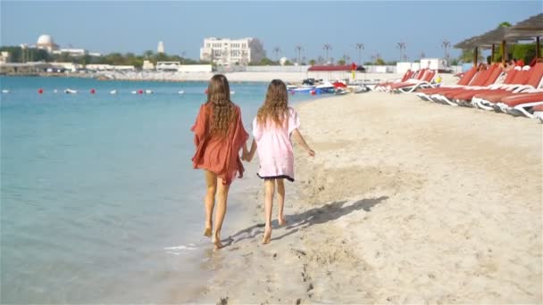 A kis vidám lányok jól érzik magukat a trópusi strandon, együtt játszanak.. — Stock videók