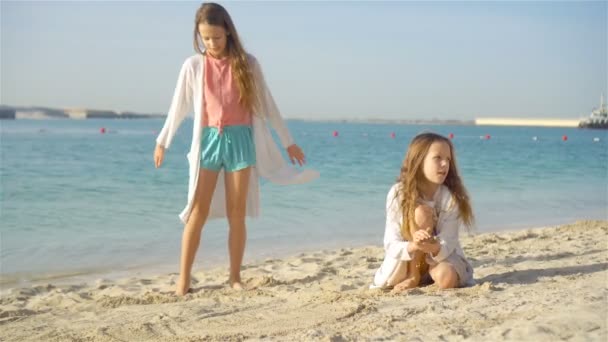 Piccole ragazze divertenti felici si divertono molto alla spiaggia tropicale giocando insieme. — Video Stock