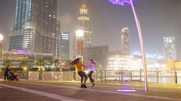 Chicas felices caminando en Dubai con rascacielos en el fondo . — Vídeo de stock