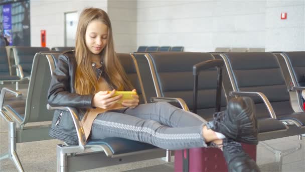 Imádnivaló kislány a repülőtéren a nagy nemzetközi repülőtér közelében ablak — Stock videók