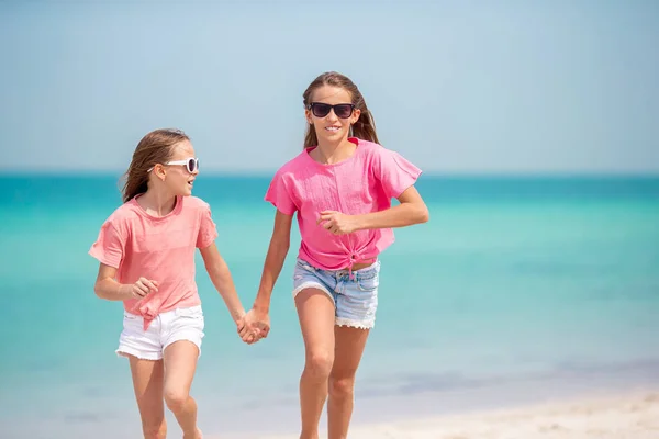 Pequenas meninas engraçadas felizes se divertir muito na praia tropical jogando juntos. — Fotografia de Stock