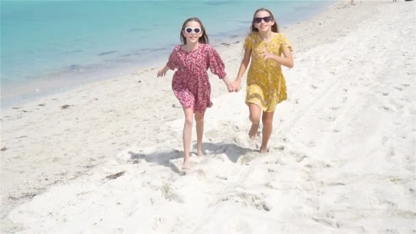 小さな幸せな面白い女の子は一緒に遊んで熱帯ビーチで多くの楽しみを持っています. — ストック動画
