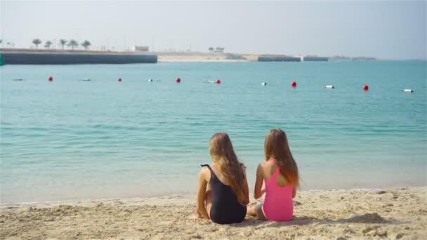 Due bambine felici si divertono molto alla spiaggia tropicale giocando insieme — Video Stock