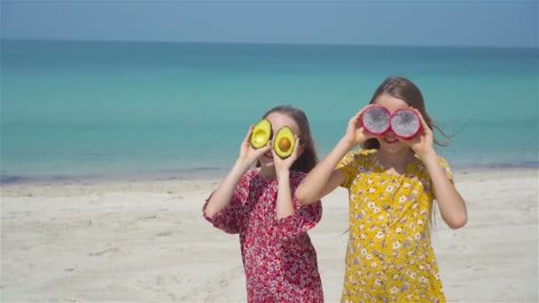 Милые маленькие девочки на пляже во время летних каникул — стоковое видео