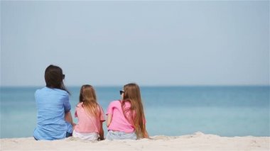 Tatlı küçük kızlar ve genç anne tropikal beyaz plajda