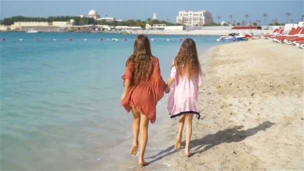 Kleine fröhliche lustige Mädchen haben viel Spaß am tropischen Strand beim gemeinsamen Spielen. — Stockvideo