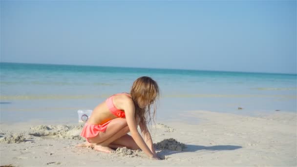 Schattig klein meisje spelen met strand speelgoed op wit tropisch strand — Stockvideo