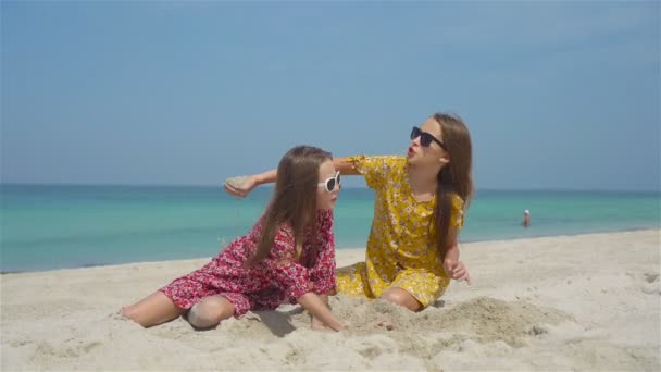 Two little happy girls have a lot of fun at tropical beach playing together — Stock Video